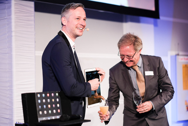iPad Zauberer Simon Pierro zapft ein Bier aus seinem Tablet beim Marken-Summit